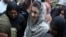 Police officers escort Maryam Nawaz as she appears at a court in Lahore in August.