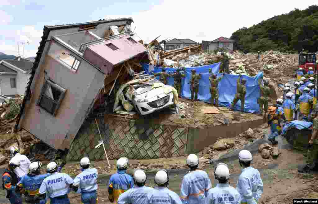 В настоящее время, по официальным данным, в Японии погибли уже 179 человек, 70 числятся пропавшими без вести. На фотографии спасатели оказывают помощь выжившим в городе Кумано в префектуре Хиросима.&nbsp; &nbsp;