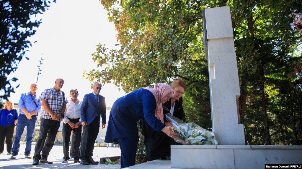 Natasha Sqepanoviq dhe familjarë e aktivistë për të pagjeturit, pranë pllakës përkujtimore për të zhdukurit me forcë, në Prishtinë, më 28 gusht 2025.