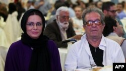 Iranian film director Dariush Mehrjui (right) and his Vahida Mohammadifar attend a ceremony in Tehran in 2015.