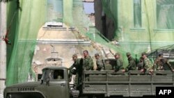 An army truck carrying Russian soldiers passes near a destroyed building in Tskhinvali on September 18.