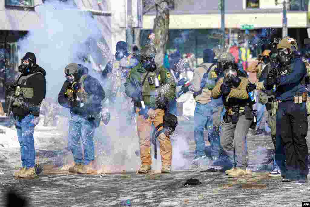 Федеральные агенты разгоняют гранатами протесты в Миннеаполисе 24 января 2026 года, вспыхнувшие после убийства мужчины иммиграционными агентами. Kerem YUCEL/AFP