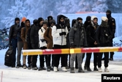 Мигранты прибывают на международный пограничный переход в Салле, провинция Лаппи в северной части Финляндии, 23 ноября 2023 года