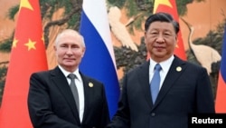 Analiștii internaționali spun că Vladimir Putin își temperează manifestările de prietenie față de Coreea de Nord pentru a nu îl supăra pe liderul chinez, Xi Jinping (dreapta).