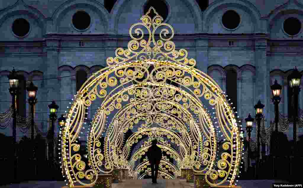 A man walks past Christmas decorations near the Cathedral of Christ the Savior in central Moscow on December 18. (AFP/Yuri Kadobnov)