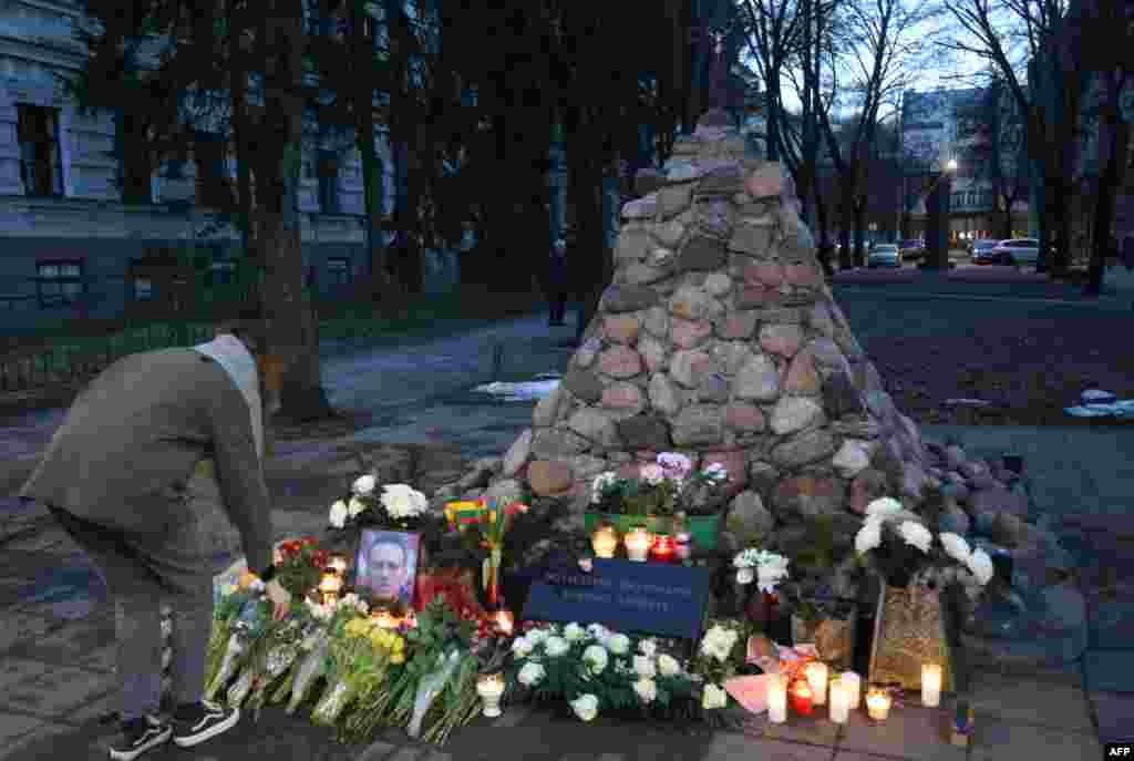 Vilnius, Lituania - O femeie lasă un buchet de flori și aprinde o candelă la o demonstrație pașnică în memoria lui Alexei Navalnîi la monumentul victimelor represiunii sovietice&nbsp;