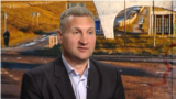 Serhiy Davydyuk, in a photo taken in Kyiv in June 2025, with an image showing the outskirts of his hometown of Nova Kakhovka in southern Ukraine.