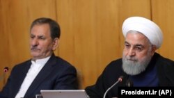 Iranian President Hassan Rouhani and Iranian First Vice President Eshaq Jahangiri (L) attend a cabinet meeting in Tehran, June 19, 2019