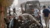 Israeli police examine the debris of the car bomb that exploded into a civilian Israeli bus (behind) in central Afula on April 6, 1994.