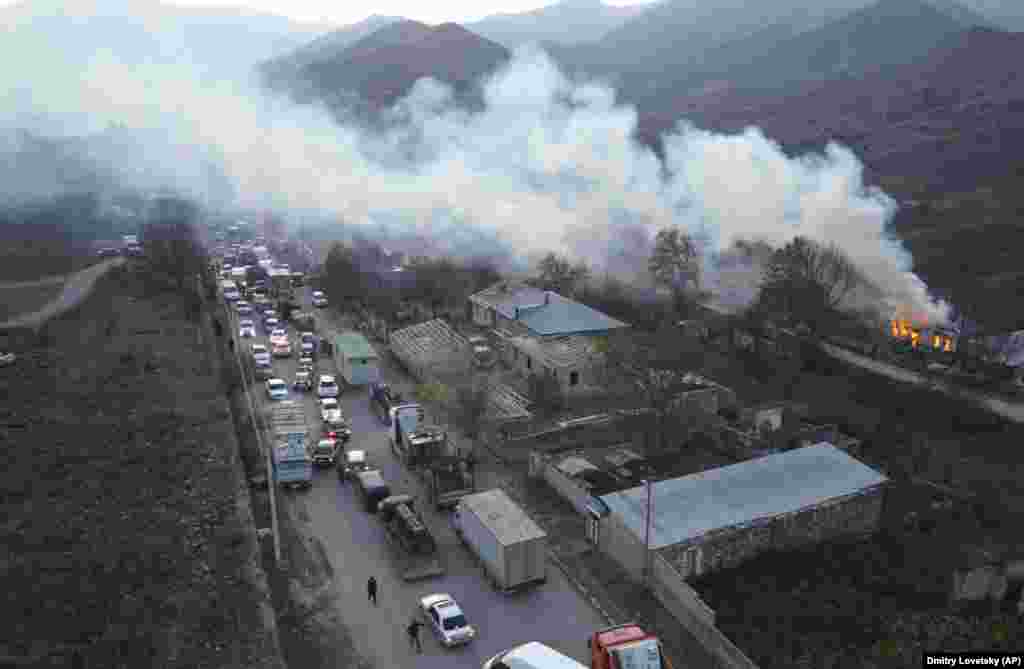 Smoke from a burning house drifts over a traffic jam as ethnic Armenians flee Karvachar/Kalbacar &ndash; which is internationally recognized as part of Azerbaijan. Ethnic Armenians point to ancient Christian monuments in the area that mark their historic ties to the land.