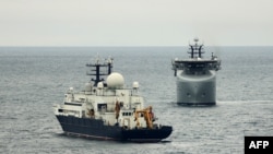 A British warship (right) tracks the Russian vessel Yantar during previous encounter.