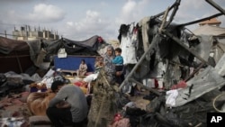 Palestinezët e zhvendosur në tendat e tyre të shkatërruara nga bombardimet e Izraelit, ngjitur me një objekt të UNRWA-së, në perëndim të qytetit Rafah. Rripi i Gazës, më 28 maj 2024.