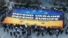 Banner chemând la apărarea Ucrainei și Europei, desfășurat de activiști europeni în fața clădirii Consiliului European de la Bruxelles, înainte de un summit european în luna martie curent 