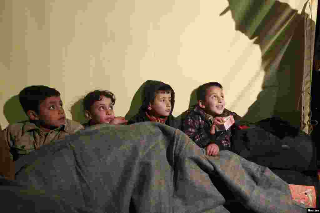 İordaniyada əsgərlər suriyalı qaçqın uşaqlara yemək və su verir 