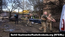 Rescue workers carry the bodies of victims from the scene of a Russian air strike in Kyiv on September 8.