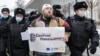 Police officers detain a protester holding a poster showing Russian President Vladimir Putin that says "Freedom for Navalny" during an unauthorized protest in support of the Russian opposition leader Aleksei Navalny in Moscow earlier this month. 