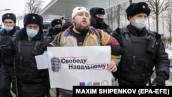 Police officers detain a protester holding a poster showing Russian President Vladimir Putin that says "Freedom for Navalny" during an unauthorized protest in support of the Russian opposition leader Aleksei Navalny in Moscow earlier this month. 