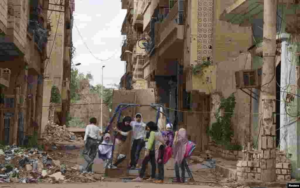 Suriyada uşaqlar dağıdılmış binaların arasında oynayırlar