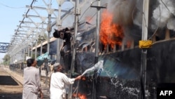 A railway official puts out a fire after a bomb blast on a train at the Sibi railway station in the southwestern Pakistani province of Balochistan. (file photo)