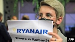 „Hol van Roman [Prataszevics]?!” transzparenssel demonstráló nő a vilniusi reptér érkező várójánál, 2021. május 23-án
