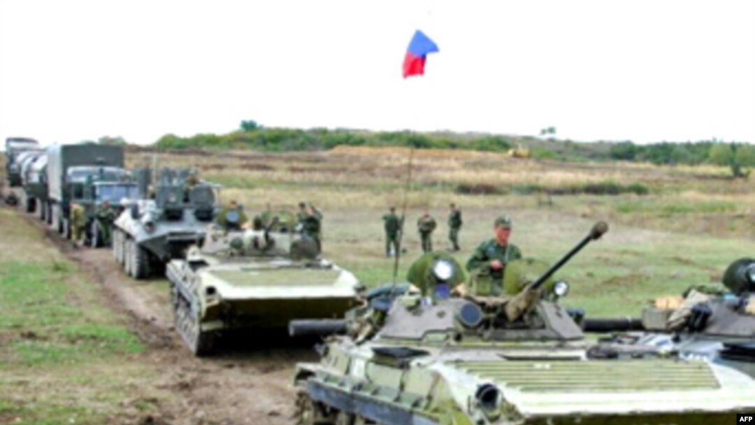 Russian soldiers sit on armored vehicles prior to their departure from a checkpoint in Kventakosa.