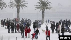 People walk along a snow covered street in the Adriatic port city of Split.