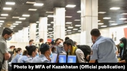 Пассажиры спецборта из Кабула и сотрудники Погранслужбы в аэропорту Алматы