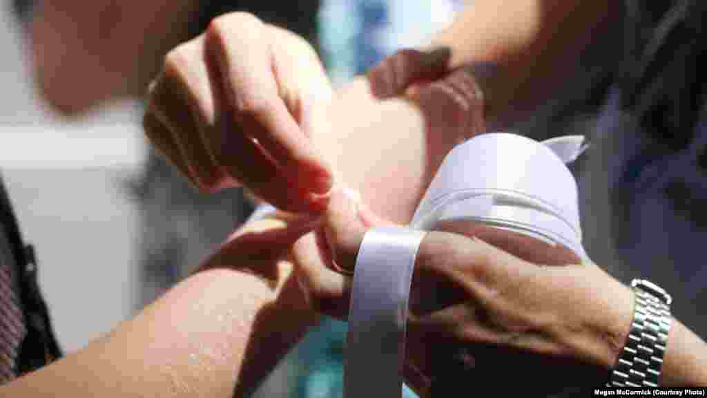 Marchers in New York tied white ribbons on each other&#39;s wrists, echoing ongoing Russian protests against government repression.