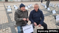 Владислав Есипенко (справа) и Николай Семена во время акции «Пустые стулья» в поддержку незаконно заключенных, пленных и пропавших без вести журналистов и художников. Киев, 15 ноября 2025 года