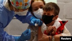 Ребенок получает свою первую дозу вакцины против коронавирусной инфекции (COVID-19) в Детском музее Explora, Италия 16 декабря 2021 года. Фото: REUTERS