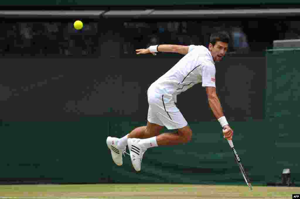 Serbia&#39;s Novak Djokovic returns a shot against the Czech Republic&#39;s Tomas Berdych during their men&#39;s singles quarterfinal match at the 2013 Wimbledon championships in London. (AFP/Carl Court)