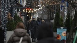 Pietoni pe o stradă decorată de Crăciun, la Kiev, pe 11 decembrie 2025. 