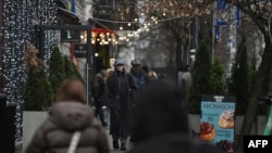 Pietoni pe o stradă decorată de Crăciun, la Kiev, pe 11 decembrie 2025. 