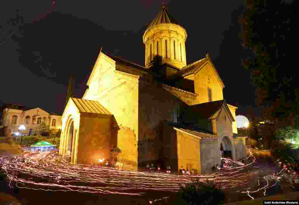 Enoriași cu lumânări aprinse, înconjurând Catedrala Sioni, cu hramul Adormirea Maicii Domnului, din Tbilisi, Georgia.