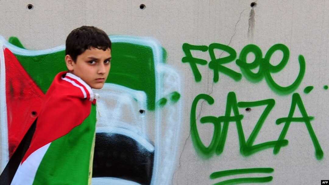 A boy wears a Palestinian flag on his shoulders during an anti-Israeli protest in front of the Israeli Consulate in Istanbul today.
