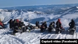 Oameni pe snowmobil în Parcul Național Munții Rodnei.