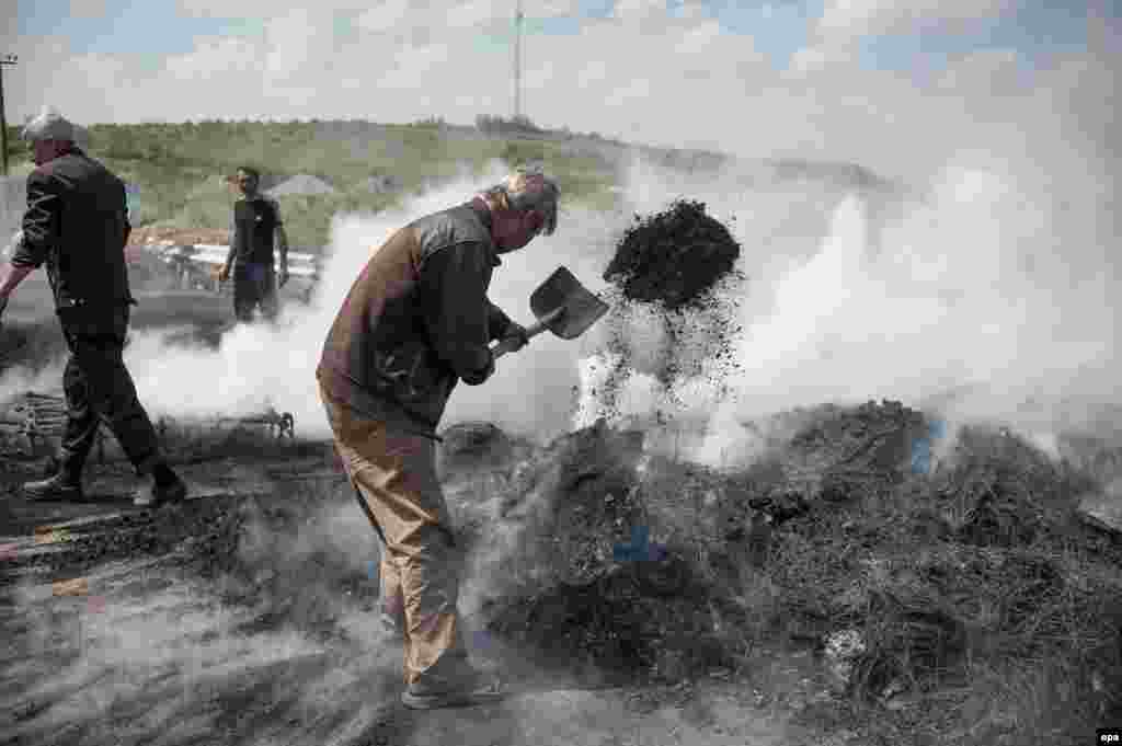 Rusiyameylli separatçılar Slavyansk yaxınlığındakı barrikadalarda yanan şinləri söndürürlər.