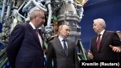 Experții spun că Vladimir Putin și-a adaptat deja economia la riscurile aduse de sancțiuni. În imagine, alături Dimitri Rogozin (stânga), fost vicepremier aflat de mai mulți ani pe lista de sancțiuni a Occidentului, în vizită la fabrica de rachete Energomash, 12 aprilie, 2019.