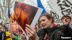 Moldovan protesters set posters depicting Russian President Vladimir Putin on fire during a rally against Russia's annexation of Ukraine's Crimea, near the Russian Embassy in Chisinau, on April 6.