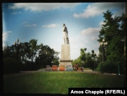 Un tren pentru copii trece pe sub un monument al poetului ucrainean, Taras Shevchenko, de pe insula Monastyrskyi, Dnipro.