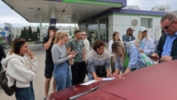 Ukraine -- People put their names on a list to join the queue for fuel at a gas station
