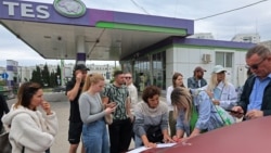 Ukraine -- People put their names on a list to join the queue for fuel at a gas station