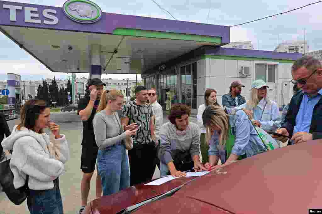People add their names to a waiting list for fuel at a gas station in Sevastopol, Crimea, on June 1. Since late May, fuel sales in Crimea have been limited to 20 liters per vehicle, with a ban on filling containers.