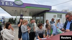 People add their names to a waiting list for fuel at a gas station in Sevastopol, Crimea, on June 1. Since late May, fuel sales in Crimea have been limited to 20 liters per vehicle, with a ban on filling containers.<br>