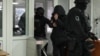 Imagini din 20 februarie 2026, când trei persoane bănuite că ar fi pregătit asasinarea unor personalități publice în Ucraina au fost escortate la Judecătoria Chișinău, după reținerea lor în cadrul unei operațiuni comune a poliției moldovene și ucrainene, supranumită „Enigma 2.0”