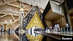 Посетители вървят до огромната статуя на Рамзес Велики в главната зала на Големия египетски музей, който беше официално открит на 1 ноември 2025 г.