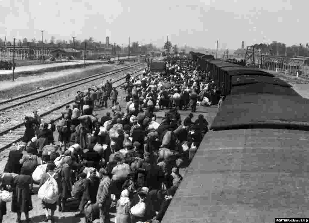 Magyar transzport érkezik Auschwitzba 1944 májusában. A kép egy vagon tetejéről készült, a ködös háttérben a II. és III. krematórium