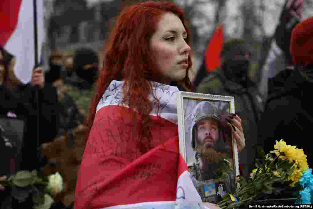 Дівчина тримає в руках портрет добровольця полку Кастуся Калиновського, командира батальйону Івана &laquo;Бреста&raquo; Марчука, який загинув у червні 2022 року на Луганщині&nbsp;