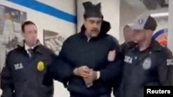 Нікаляса Мадуру суправаджаюць фэдэральныя агенты на базе Ўпраўленьня па барацьбе з наркотыкамі ЗША ў Нью-Ёрку (стоп-кадар зь відэа)