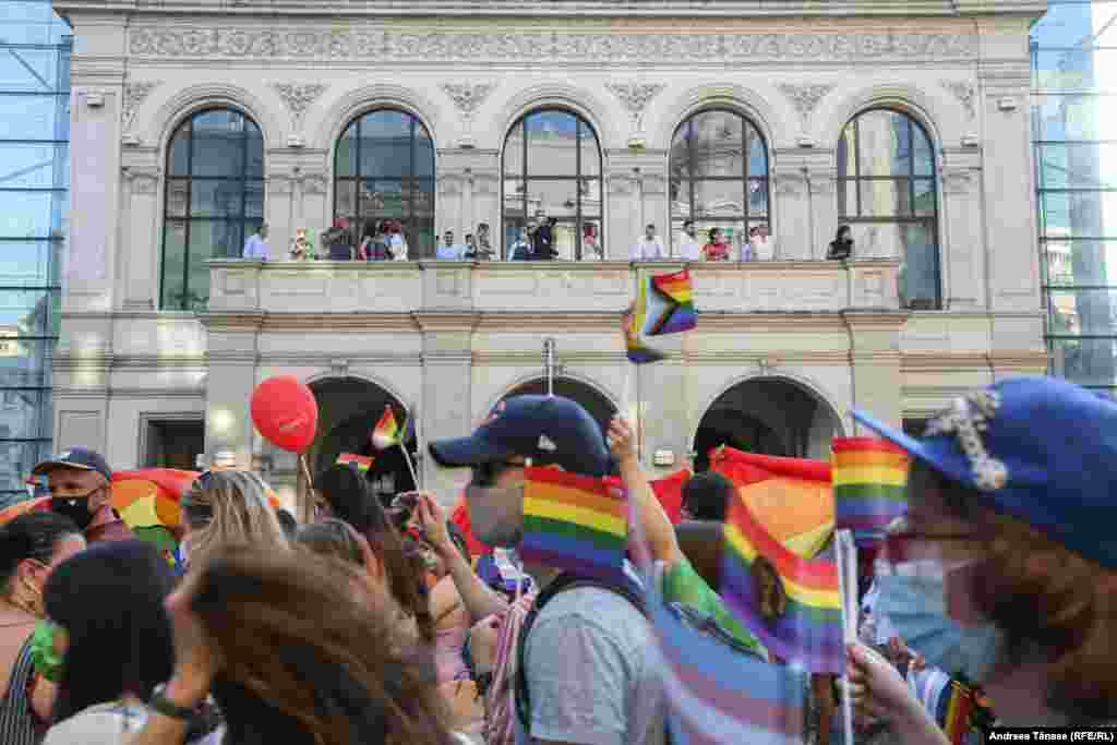 Mai multe persoane privesc marșul Bucharest Pride, din balconul Hotelului Novotel.&nbsp;